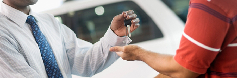 vendedor de automóviles con llaves de un vehículo en mano